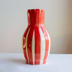 fotografia de jarra de ceramica a rayas rojas y blancas
