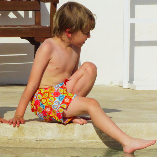 fotografia de niño sentado con bañador sunlight
