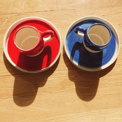 conjunto de plato y taza azul y rojo