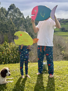 fotografía de padre con su hijo llevando pijamas aqua parade a juego sujetando peces