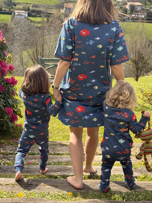 Fotografía de espaldas de madre con sus hijas. Una niña lleva el conjunto de dos piezas de pijama y la otra el mono. Conjunto Aqua Parade