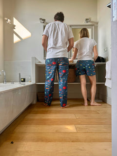 Fotografía de espaldas de pareja llevando pantalon largo y pantalon corto de aqua parade.