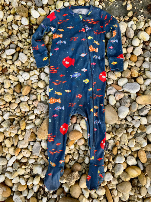 pijama de bebé tendido sobre lecho de rocas