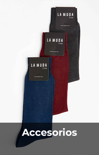 Tres pares de calcetines de La Muda Club en colores gris oscuro, rojo burdeos y azul marino, cada uno con su etiqueta. Imagen etiquetada con 'Accesorios' en la parte inferior.