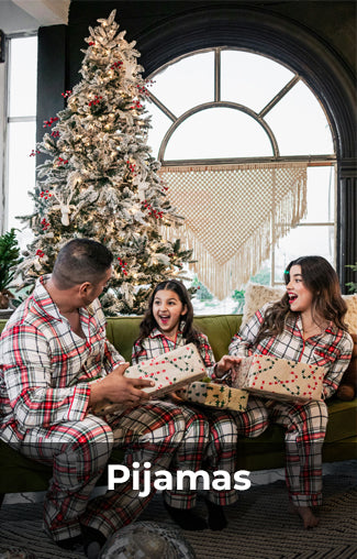 Familia de tres personas usando pijamas a cuadros rojos y blancos, sentados alrededor de un árbol de Navidad decorado, abriendo regalos. Imagen vibrante y festiva con el texto 'Pijamas' al pie.