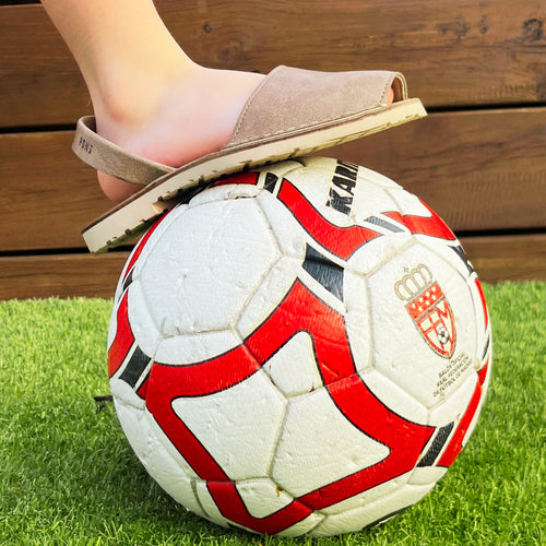 sandalia sobre pelota de futbol