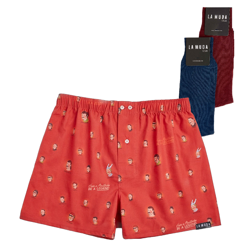 Conjunto de ropa de La Muda Club sobre fondo transparente, incluyendo shorts rojos estampados con caras y la frase 'Be a Legend', y dos pares de calcetines, uno azul y otro burdeos, cada uno con su respectiva etiqueta de la marca.