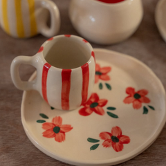 taza a rayas rojas y plato flores